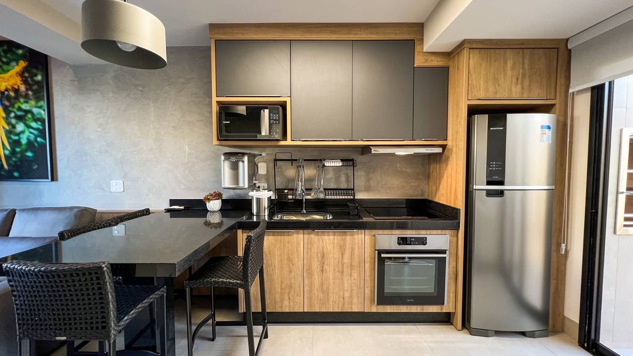 Cozinha com forno, cooktop, micro-ondas e geladeira inox